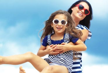 Happy family in sunglasses on beach (Photo: Shutterstock)