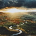 a windy road for a road trip with a moody sky