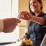 Guest takes room key card at check-in desk of hotel (Photo: Shutterstock)