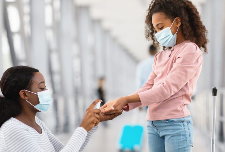 Teen girl and mother using hand sanitizer at the airport (Photo: Shutterstock)