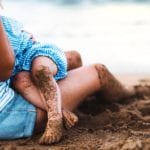 Mother breastfeeding child on the beach (Photo: Shutterstock)