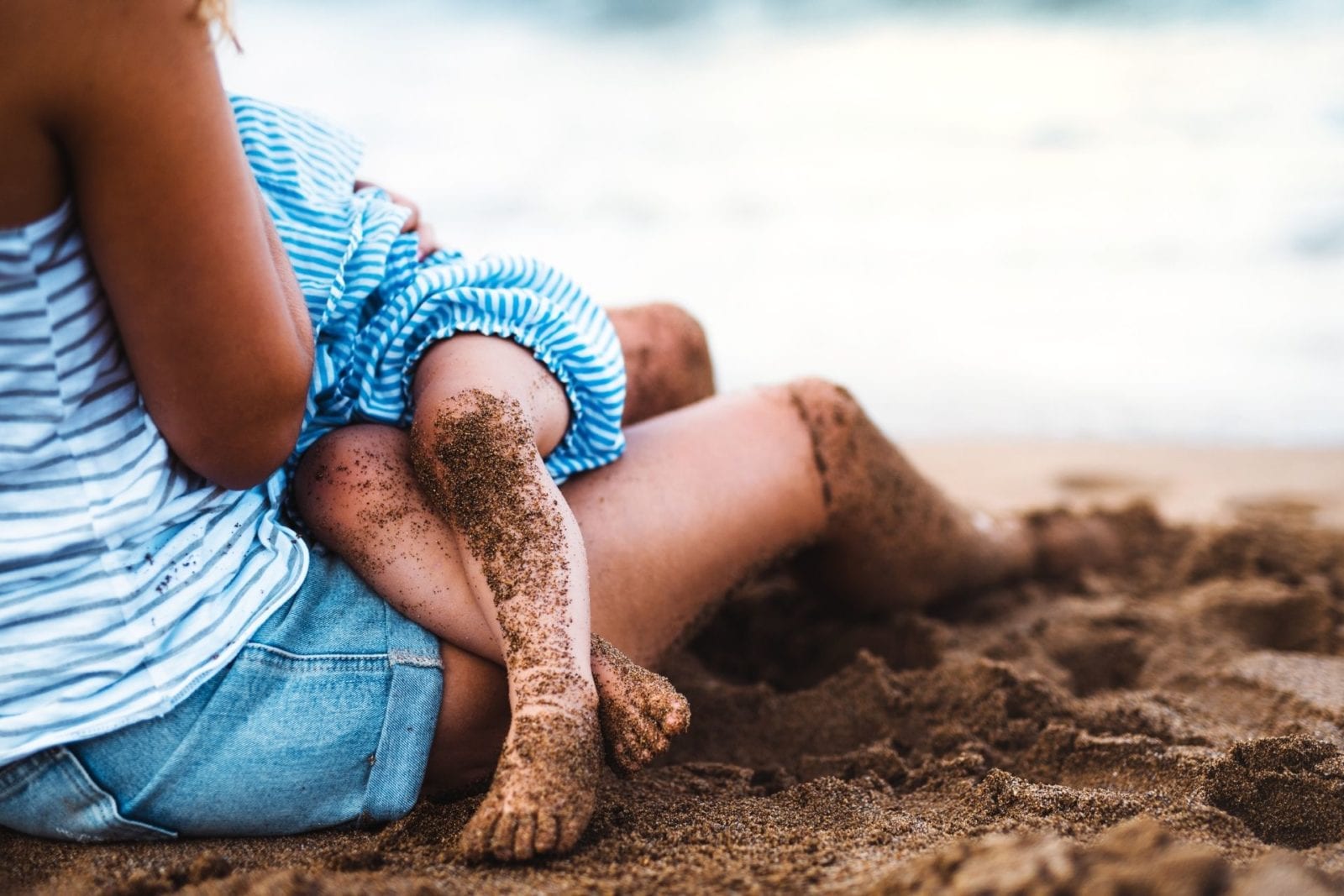 Mother breastfeeding child on the beach (Photo: Shutterstock)