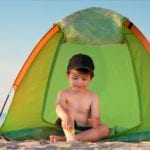 Little boy playing near a beach tent (Photo: Levranii / Shutterstock)