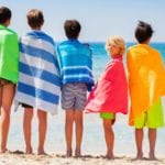 Kids drying off with beach towels after swimming (Photo: Sergey Novikov / Shutterstock)