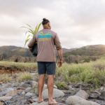 Kiai Collier of Hawaii Land Trust walks with a hala (pandanus) sapling to a reforestation site