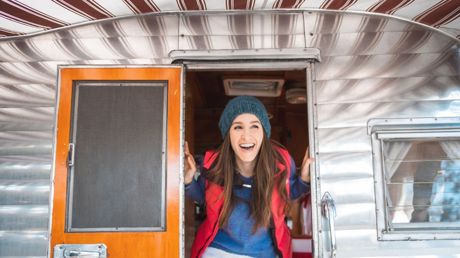 Woman poking her head out of a vintage RV (Photo: @jordvdz via Twenty20)