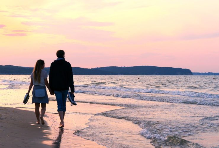 Beach couple holding hands at sunset (Photo: @TatianaMara via Twenty20