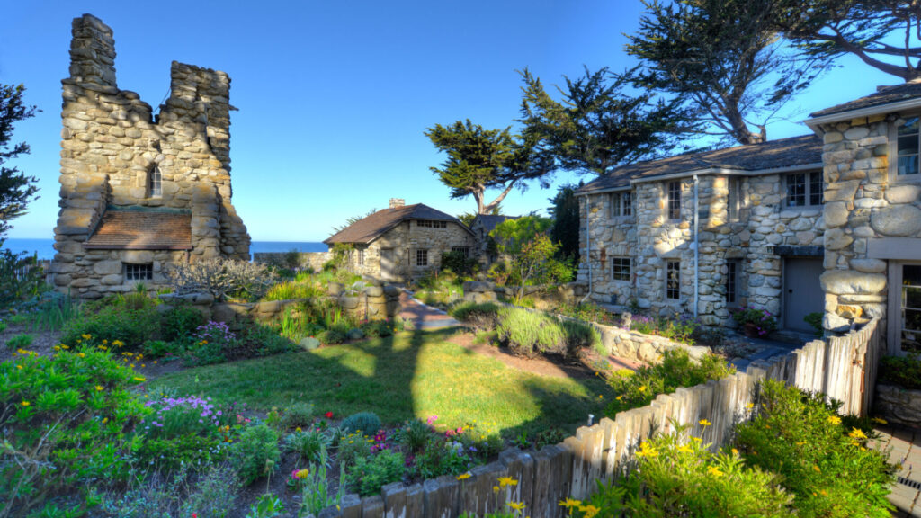 old stone buildings in Carmel by the Sea with the Pacific Ocean in the background