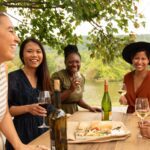 Girlfriends enjoy wine and snacks at a picnic table at Doukenie Winery (Photo: Todd Wright / Visit Loudoun)