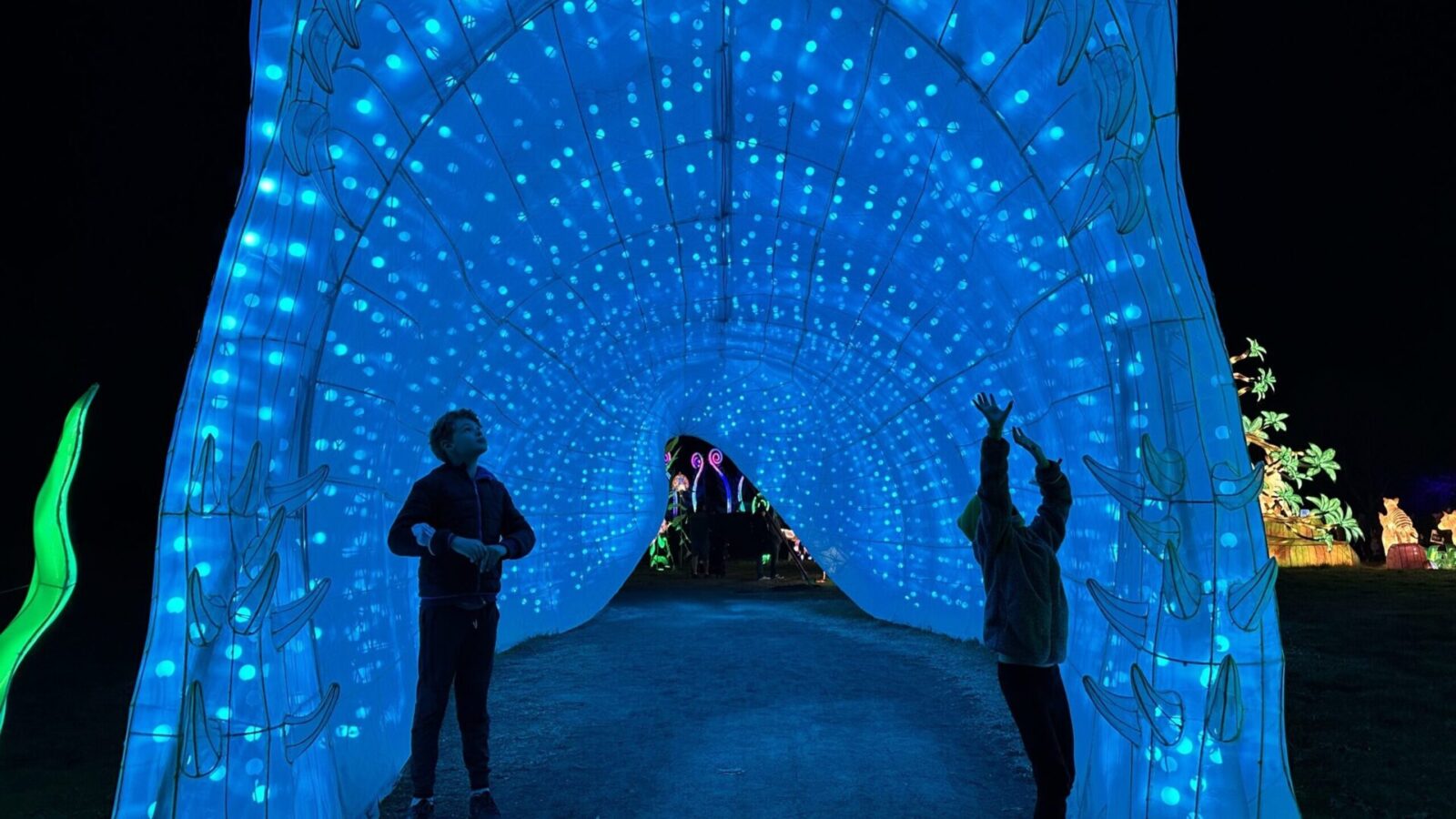 kids in the megalodon tunnel at Glowfari at the Oakland Zoo.