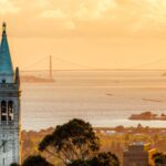 Sather Tower at UC Berkeley campus, with Berkeley and the Golden Gate Bridge in the background.