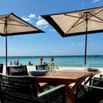 Tables in the sand at the Coccoloba Restaurant at the Seven Mile Beach resort Kimpton Seafire