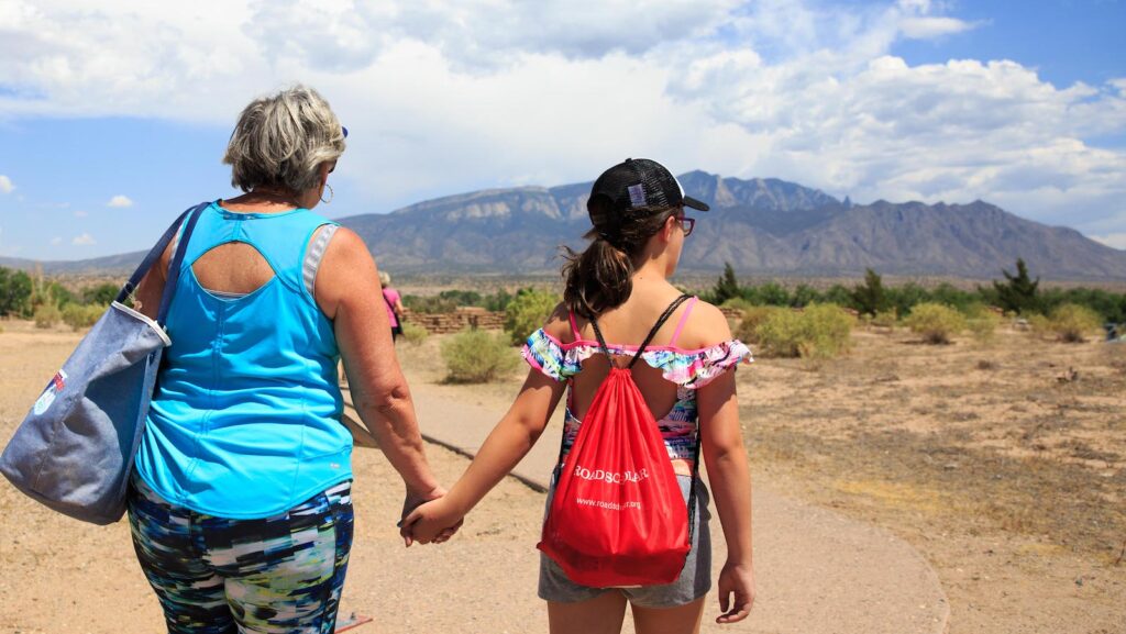 Person holds had with granddaughter while taking in the view