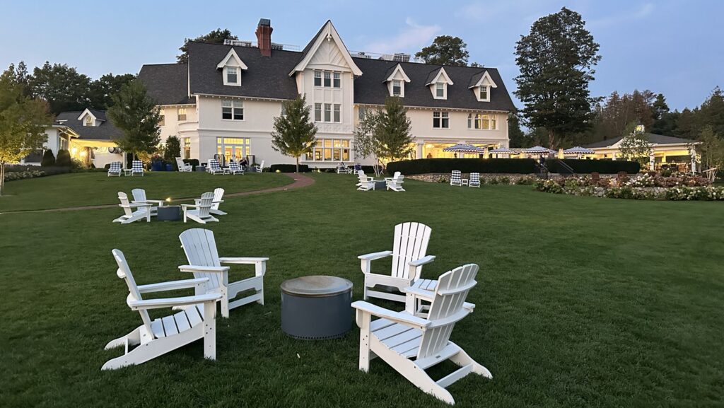 Adirondack chairs around a firepit on the Straits Lawn at The Inn at Stonecliffe