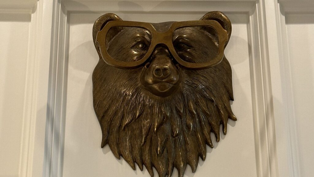 A brass bear head wearing glasses hanging on the wall at The Inn at Stonecliffe