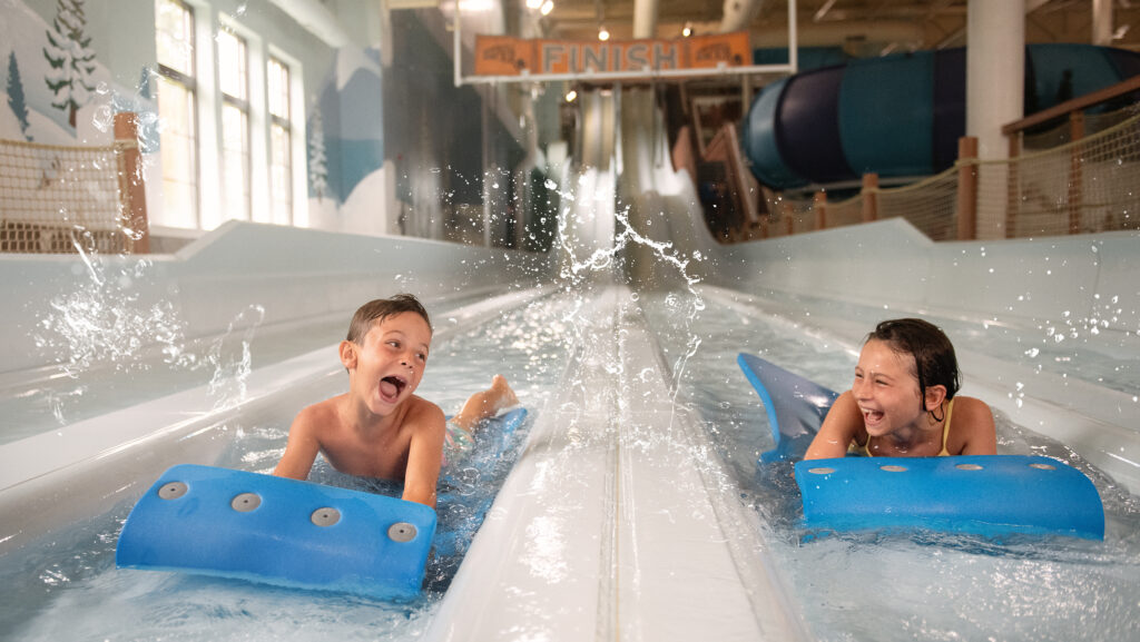 Two kids racing on a mat waterslide at Boyne Mountain Resort