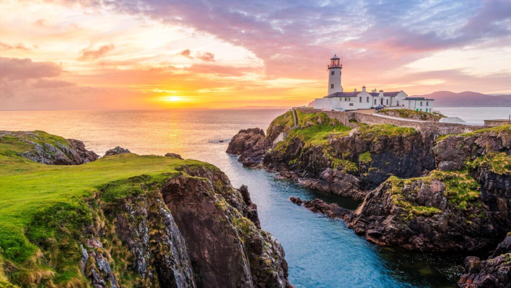 An Irish landscape with a lighthouse at sunset