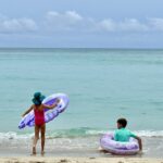 Kids playing in the calm waters at Waikiki Beach near the Royal Hawaiian