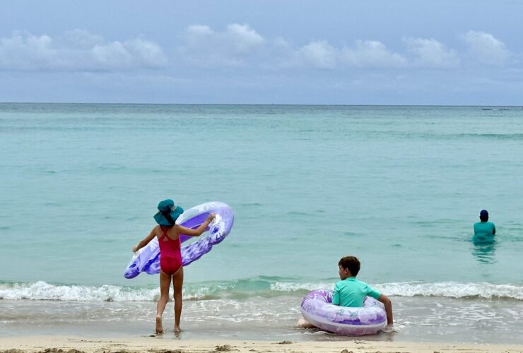 Kids playing in the calm waters at Waikiki Beach near the Royal Hawaiian